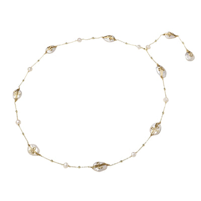 Long gold chain necklace with baroque pearls wrapped in leaf designs and small freshwater pearls spaced along the strand